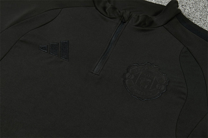 Blacked out adidas logo and Manchester United crest detail on black training top